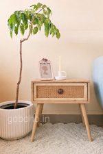 Natural wood side table with woven cane drawer and tapered legs - goBoho